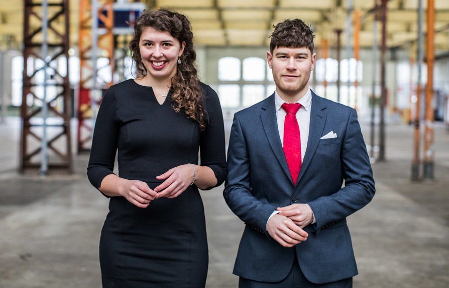 Formele portretten van twee professionele advocaten in een industriële omgeving.